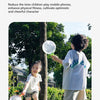 A young child is playing with a green foot launcher toy and a white flying disc in a grassy outdoor setting.