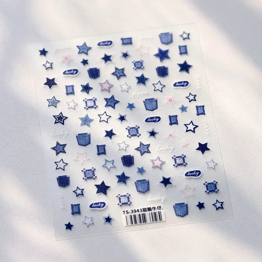A sheet of translucent nail art stickers featuring various star and geometric shapes in blue and pink shades.