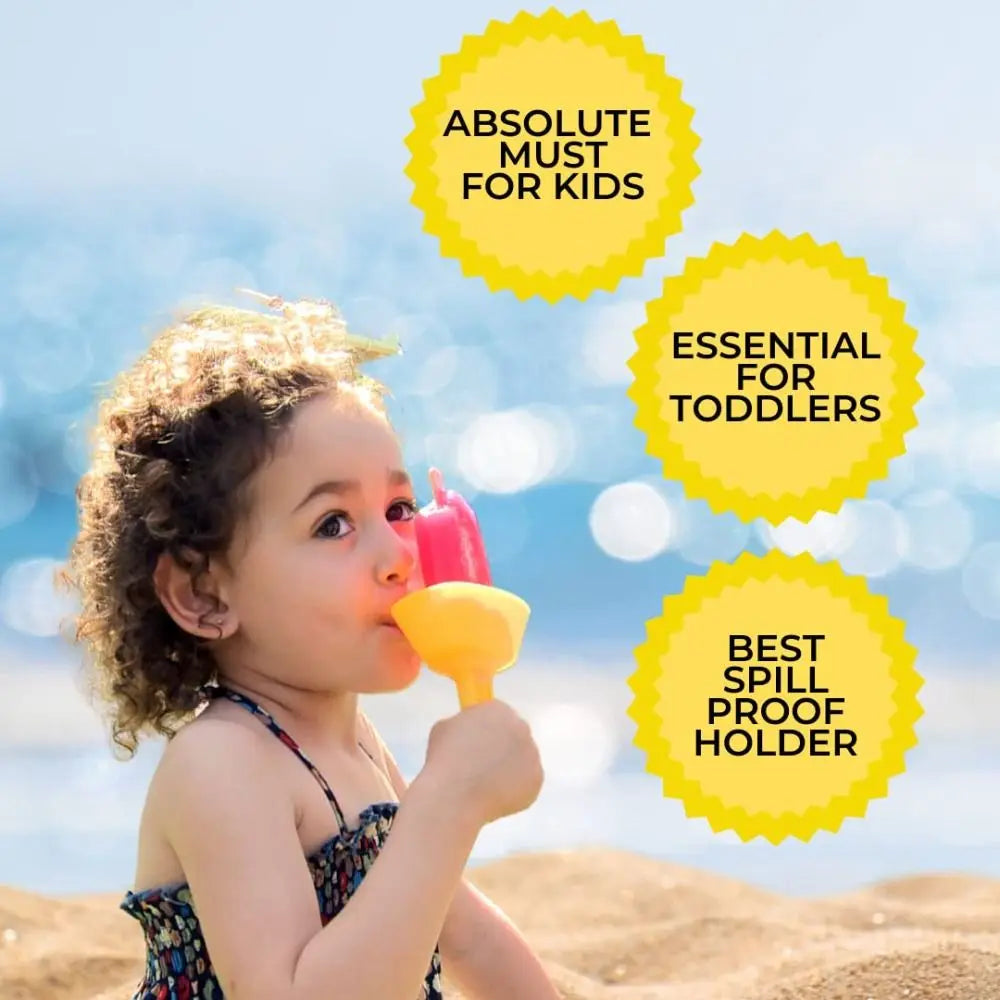 A young child is holding a yellow popsicle in a drip-proof holder, set against a blurred beach background.