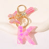 Gold initial K keychain with pink butterfly charm and pink acrylic letter.