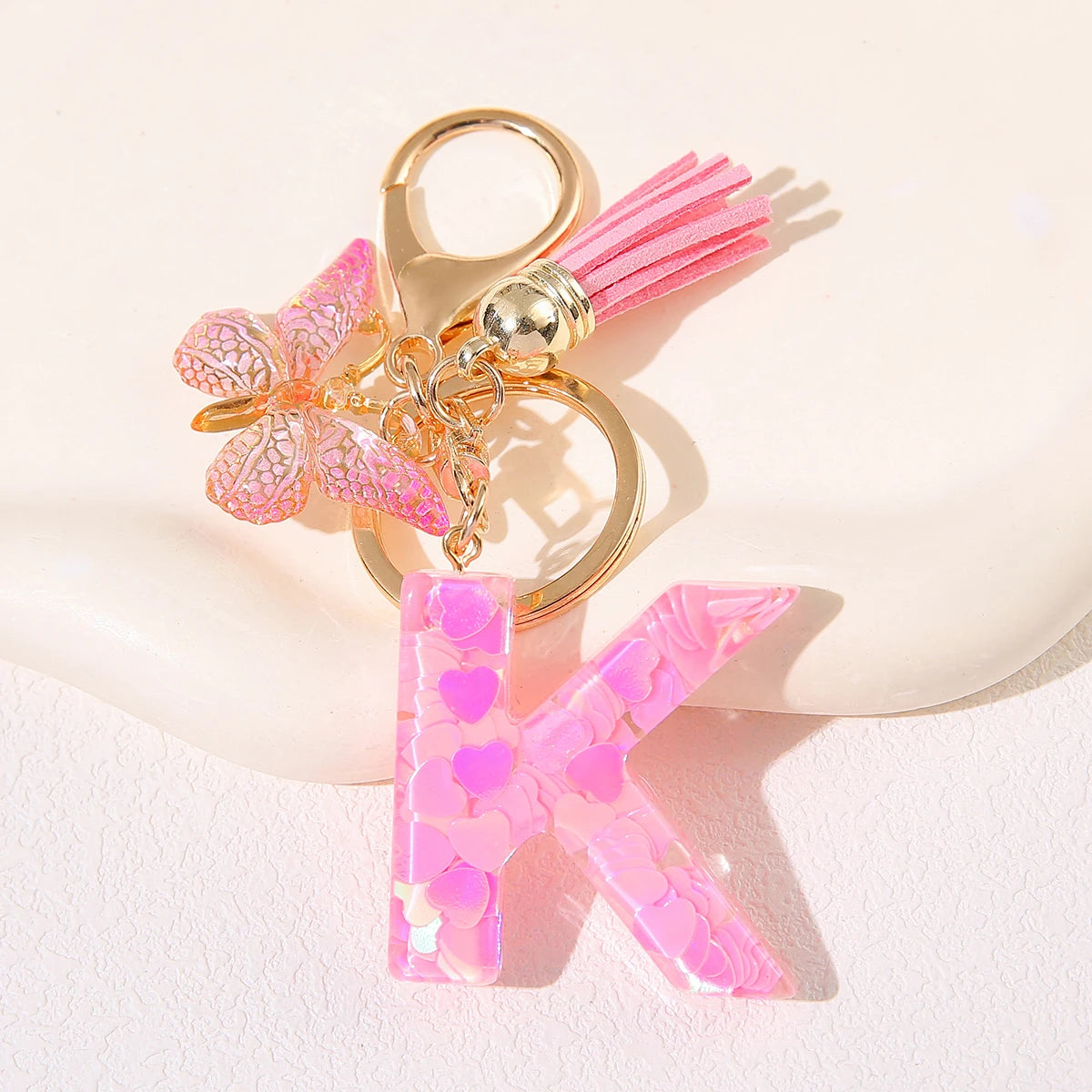 Gold initial K keychain with pink butterfly charm and pink acrylic letter.