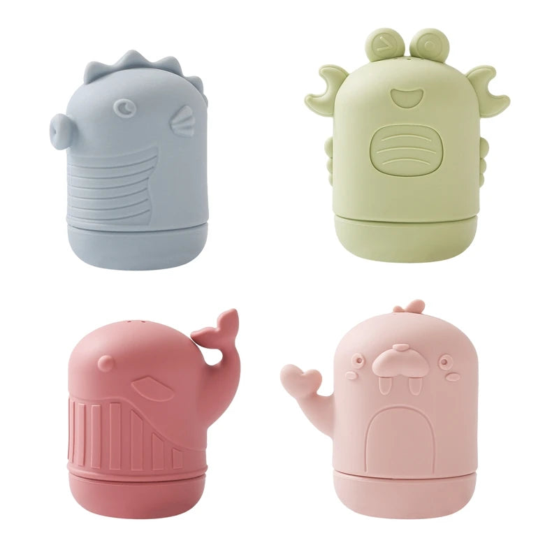 Three soft silicone animal bath toys in blue, light green, and pink.