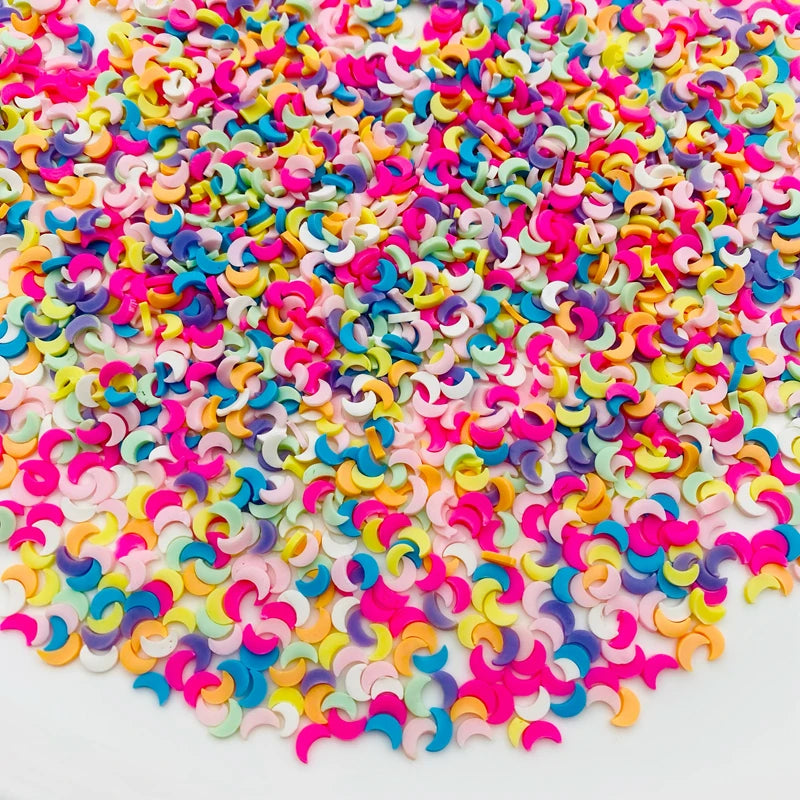 A pile of colorful polymer clay star and heart sprinkles in various shades of pink, purple, yellow, and blue.