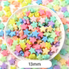 A bowl filled with pastel bear-shaped acrylic craft beads in various shades of pink, yellow, green, and purple.