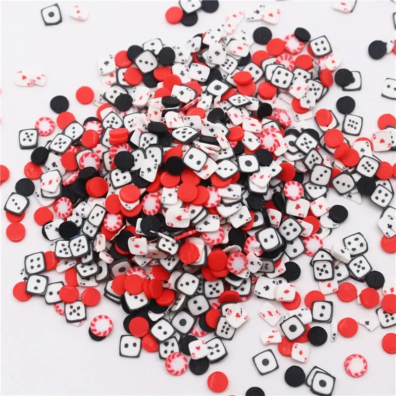 A pile of small polymer clay flower charms in black and white with red accents for DIY crafts.