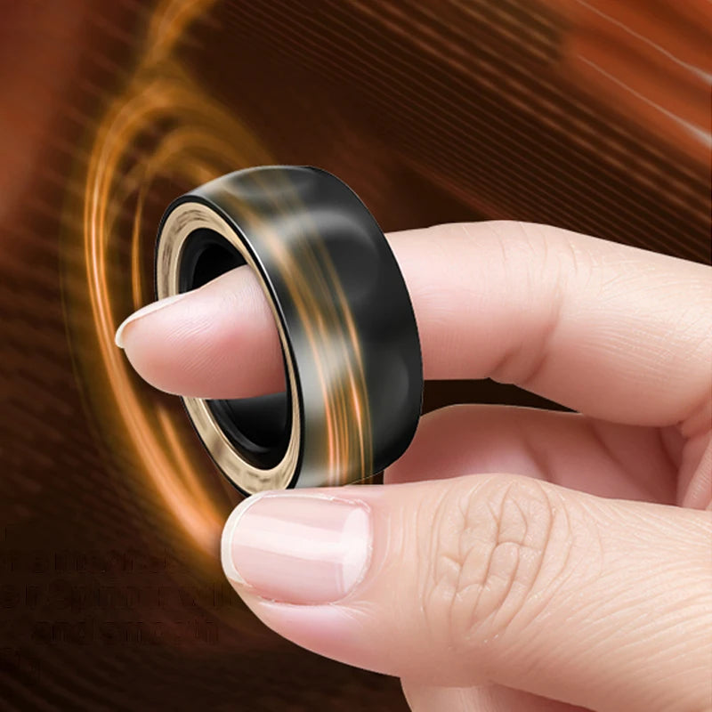 A hand is holding a black and gold magnetic fidget ring, showing its texture and design.
