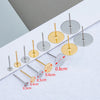 A collection of stainless steel earring stud bases in various sizes and gold and silver finishes laid out on a white surface.