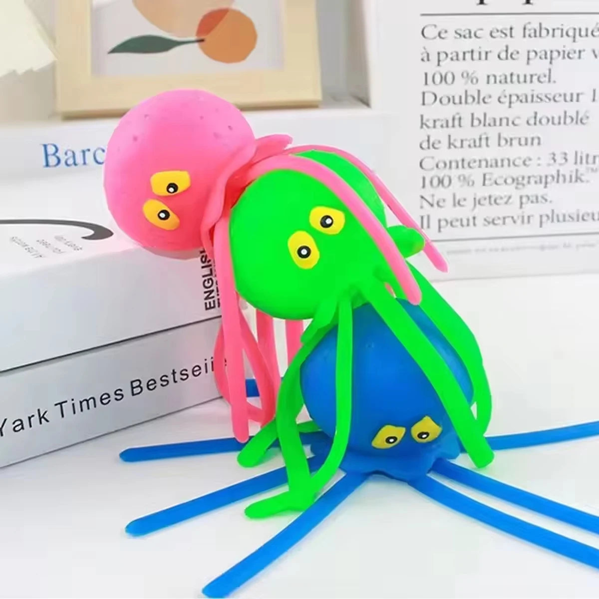 A bright green squeeze water octopus bath toy with pink tentacles is shown against a white background.