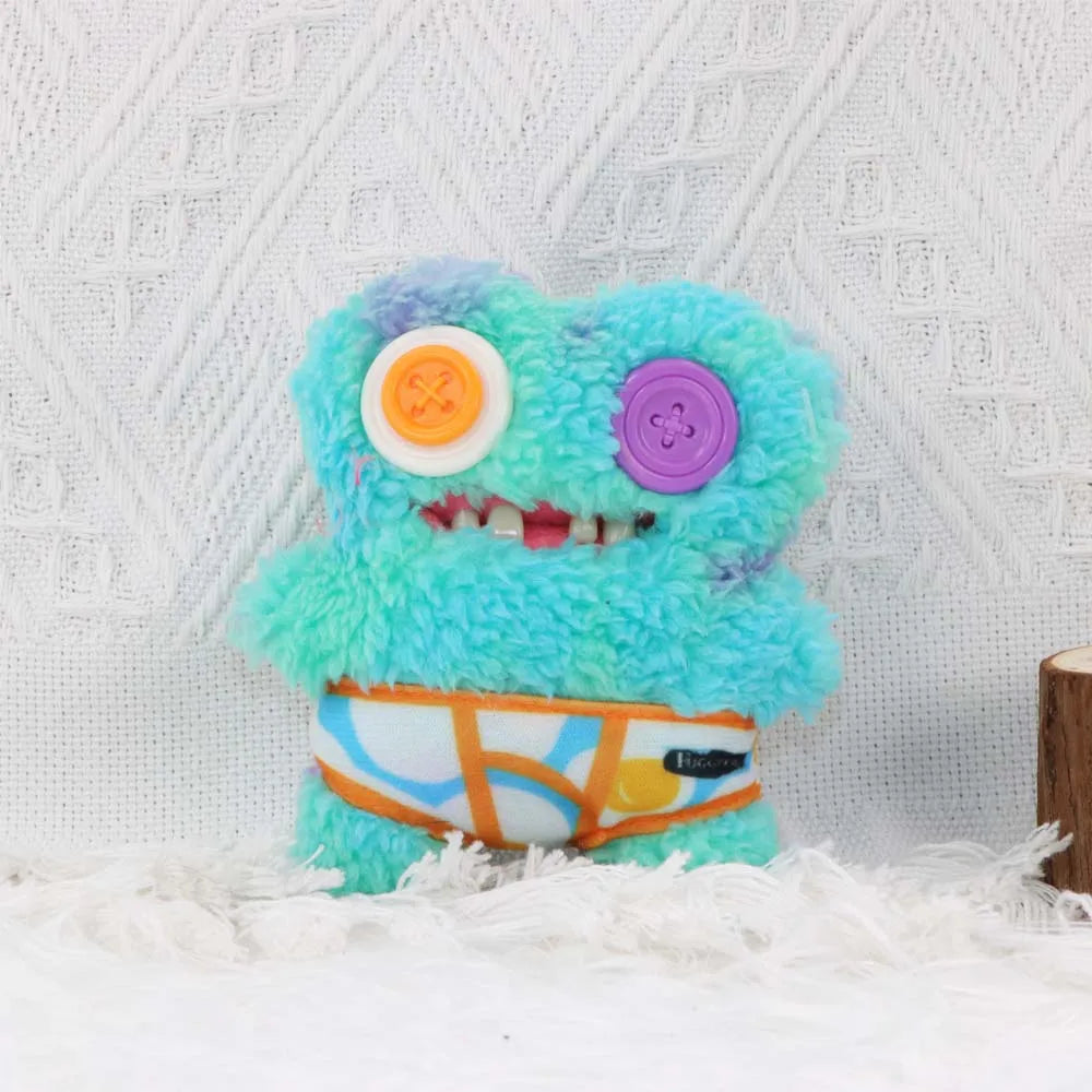 A fluffy, bright blue and purple monster plush toy with large eyes and an orange belly, displayed against a white textured ba