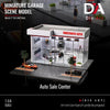 A miniature garage scene model of a two-story auto sale center with display cases and parking area.