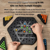 A hand inserts a piece into a hole on a black triangle board to form a larger triangle structure.