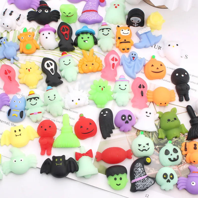 A collection of soft squishy toys in various colors and shapes, including pumpkins, ghosts, and animals.