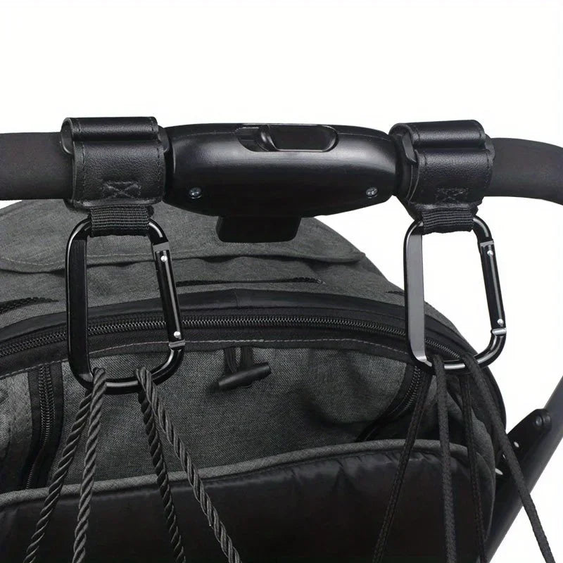 Black heavy-duty stroller hooks attached to a black fabric bag or carrier.