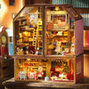 A detailed wooden miniature dollhouse kit featuring multiple levels and decorative elements.