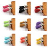 A collection of mixed color velvet tassels in various shades including pink, black, red, and purple, displayed on wooden bloc