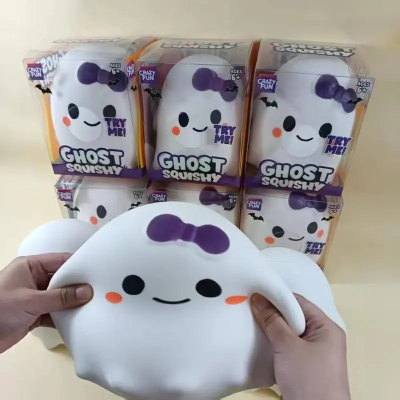 A hand holds a white ghost squishy stress relief toy next to packaged versions.
