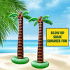 Two inflatable palm trees with green fronds and brown trunks sitting on a sandy beach.