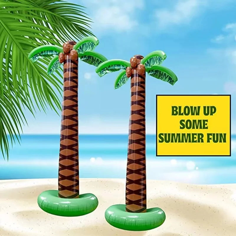 Two inflatable palm trees with green fronds and brown trunks sitting on a sandy beach.