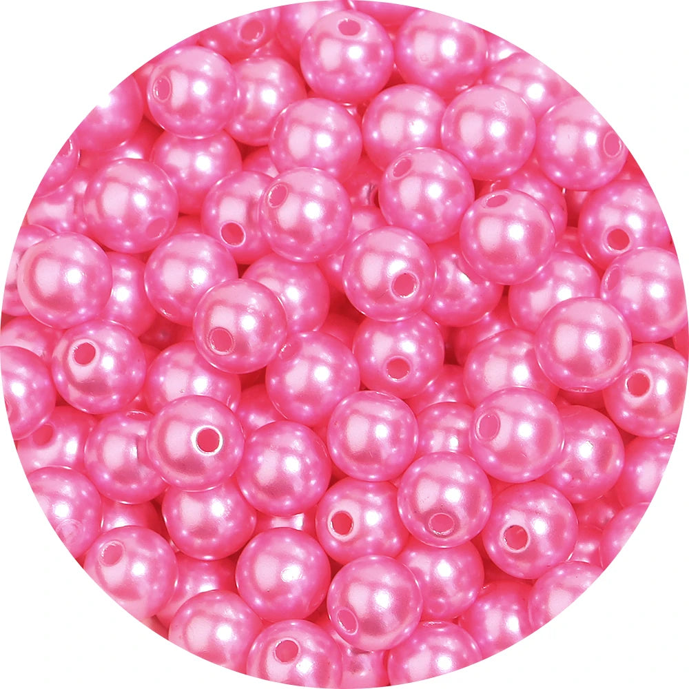 A close-up view of pink imitation pearl beads used for DIY jewelry making.