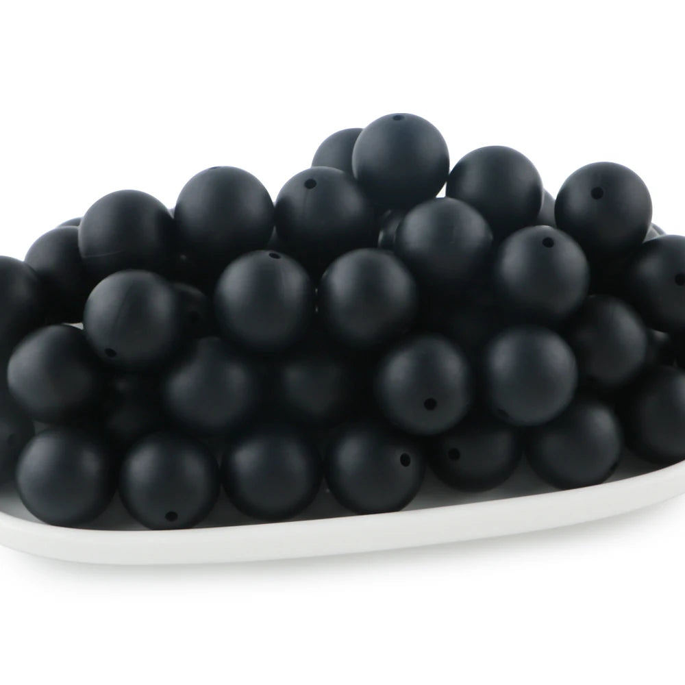 A pile of small, round black silicone beads for jewelry making and DIY crafts.