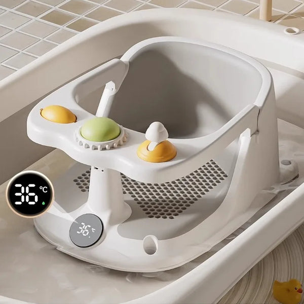 A white non-slip baby bath seat with yellow and green toys is placed in a bathtub.