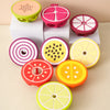 A set of silicone baby teethers shaped like various fruits and vegetables in pink, yellow, and orange colors.