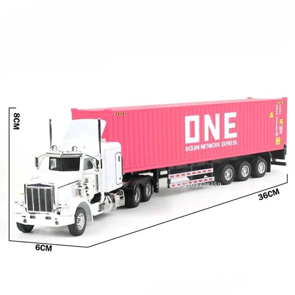 A white diecast container truck model on a flat surface with a pink shipping container in the background.