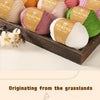 A collection of Merino wool yarn in various shades of pink, yellow, green, and beige is displayed in a wooden box.