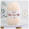 A ball of soft peach colored chenille yarn with a white label and Chinese characters for knitting and crochet.