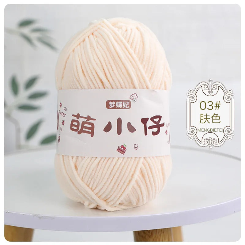 A ball of soft peach colored chenille yarn with a white label and Chinese characters for knitting and crochet.