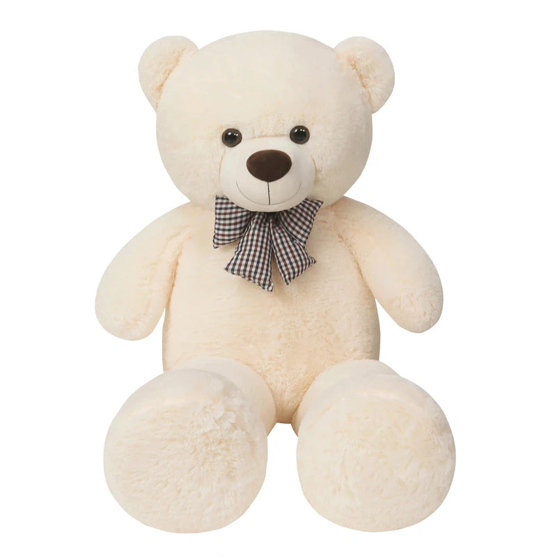 A large, cream-colored teddy bear plush toy with a brown nose and a checkered bow tie.