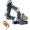 A remote control construction excavator truck with a yellow body and black arm is being operated by a hand.