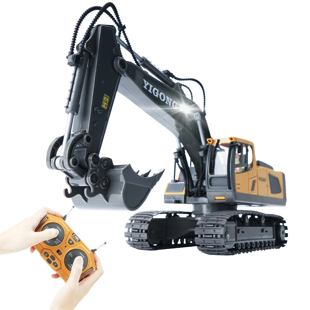 A remote control construction excavator truck with a yellow body and black arm is being operated by a hand.
