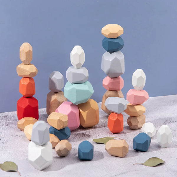 A collection of wooden sensory stacking blocks in various pastel and earthy tones stacked vertically on a light surface.