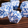 A close-up of several white dice with blue markings are scattered on a wooden surface.