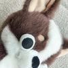 A brown and white chihuahua plush doll with its tongue sticking out