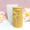 A light tan silicone candle mold shaped like a hooded skull with a detailed face design, next to a white cylindrical object a
