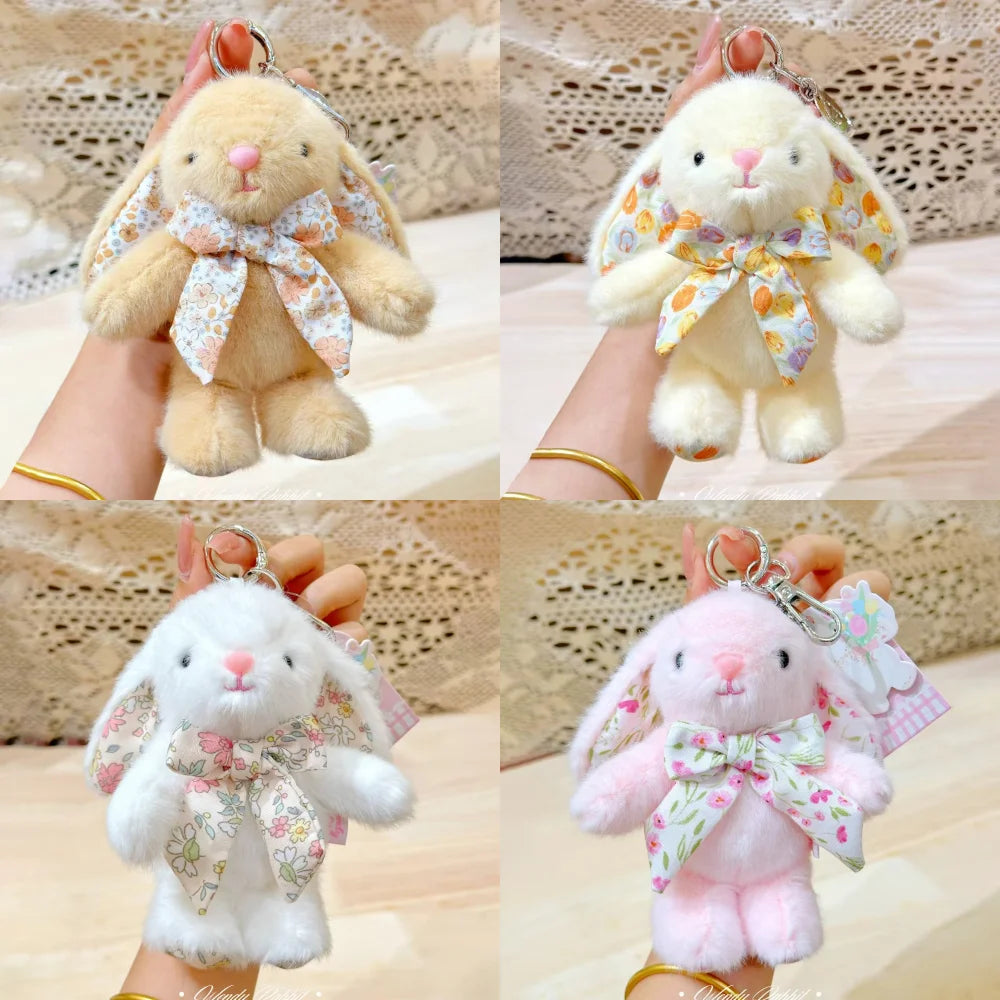 A soft pink bunny plush keychain with a floral bow charm is shown in multiple angles.