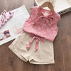 A pink floral chiffon sleeveless top and matching beige shorts set for a girl displayed on a wooden surface.