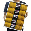 A box containing five skeins of yellow alpaca wool yarn for knitting and crochet.
