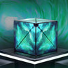 A geometric magnetic fidget cube with a vibrant teal and blue marbled surface displayed on a dark stand.