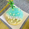 A silicone baking mold set featuring a light blue ice-like substance topped with green leaves and seashells on a white plate.