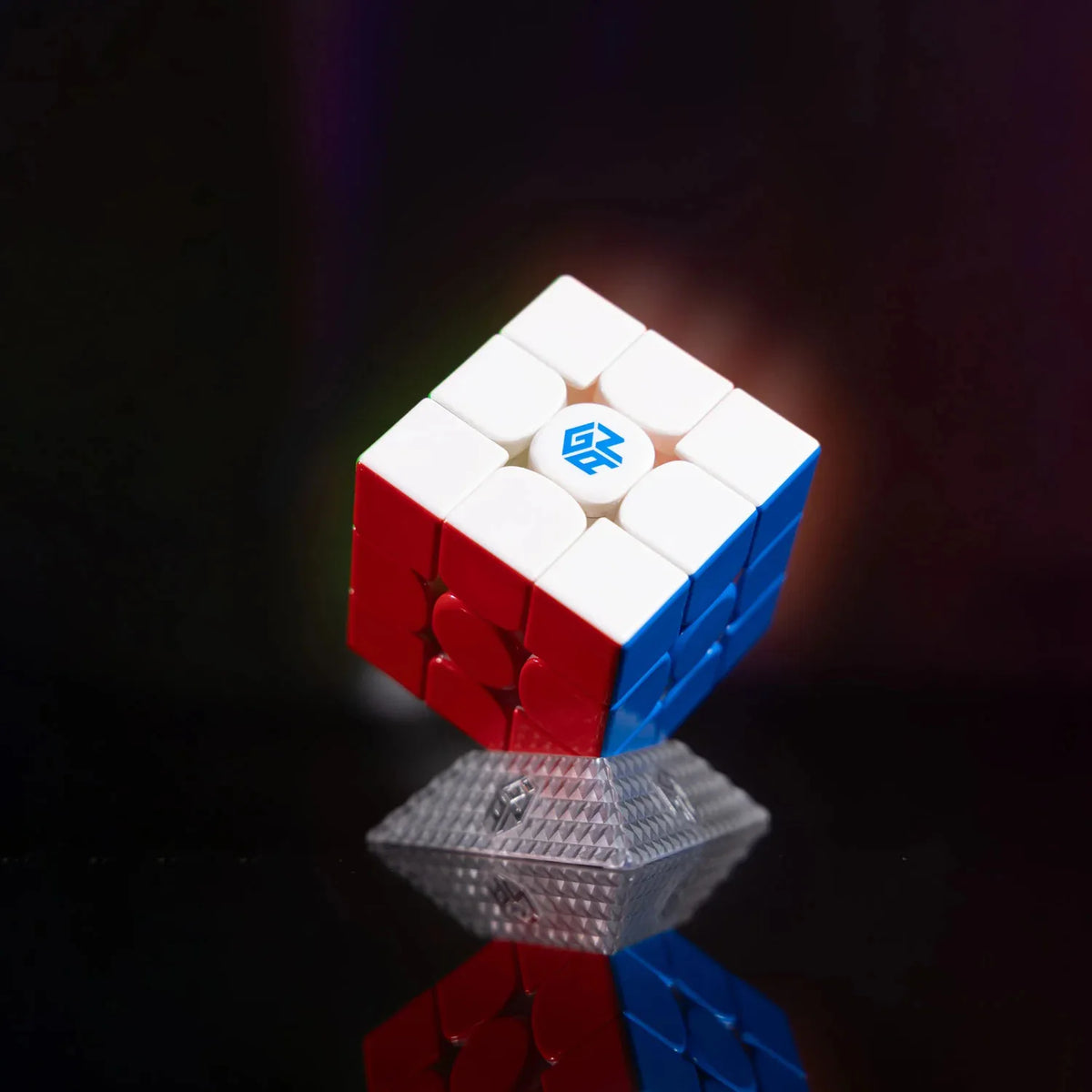 A blue and red GAN 16 Maglev Max UV 3x3 magnetic speed cube resting on a reflective surface.