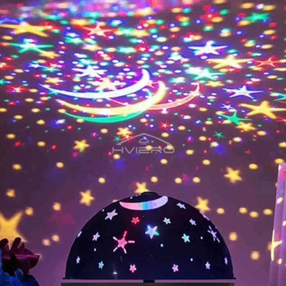 A projection of a starry night sky with colorful stars and a crescent moon on a dome-shaped surface.