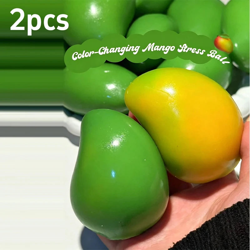 Two green and yellow color-changing mango stress balls are shown in a hand.