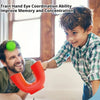 A boy is practicing hand-eye coordination by catching a green ball thrown by a man using an orange U-shaped toy.