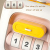 A pink and yellow Montessori busy cube with numbered buttons for toddlers.