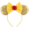 A yellow bow headband accessory set featuring a red rose and gold sequin accents.