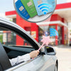 A hand holds a pink magic wand with a credit card holder graphic floating above a car window.