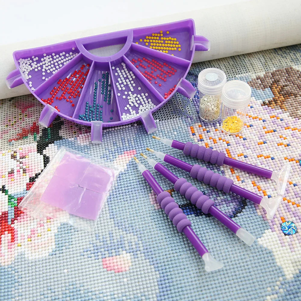 A purple diamond painting organizer tray with six compartments filled with colored sequins and a pen is displayed on a map ba